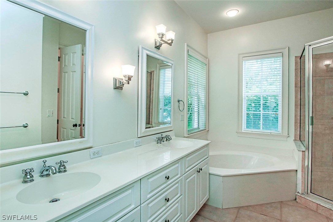 1358 Sand Castle Road Sanibel, FL 33957 - Photo 17 of 26 a bathroom with a tub a sink double vanity and a mirror