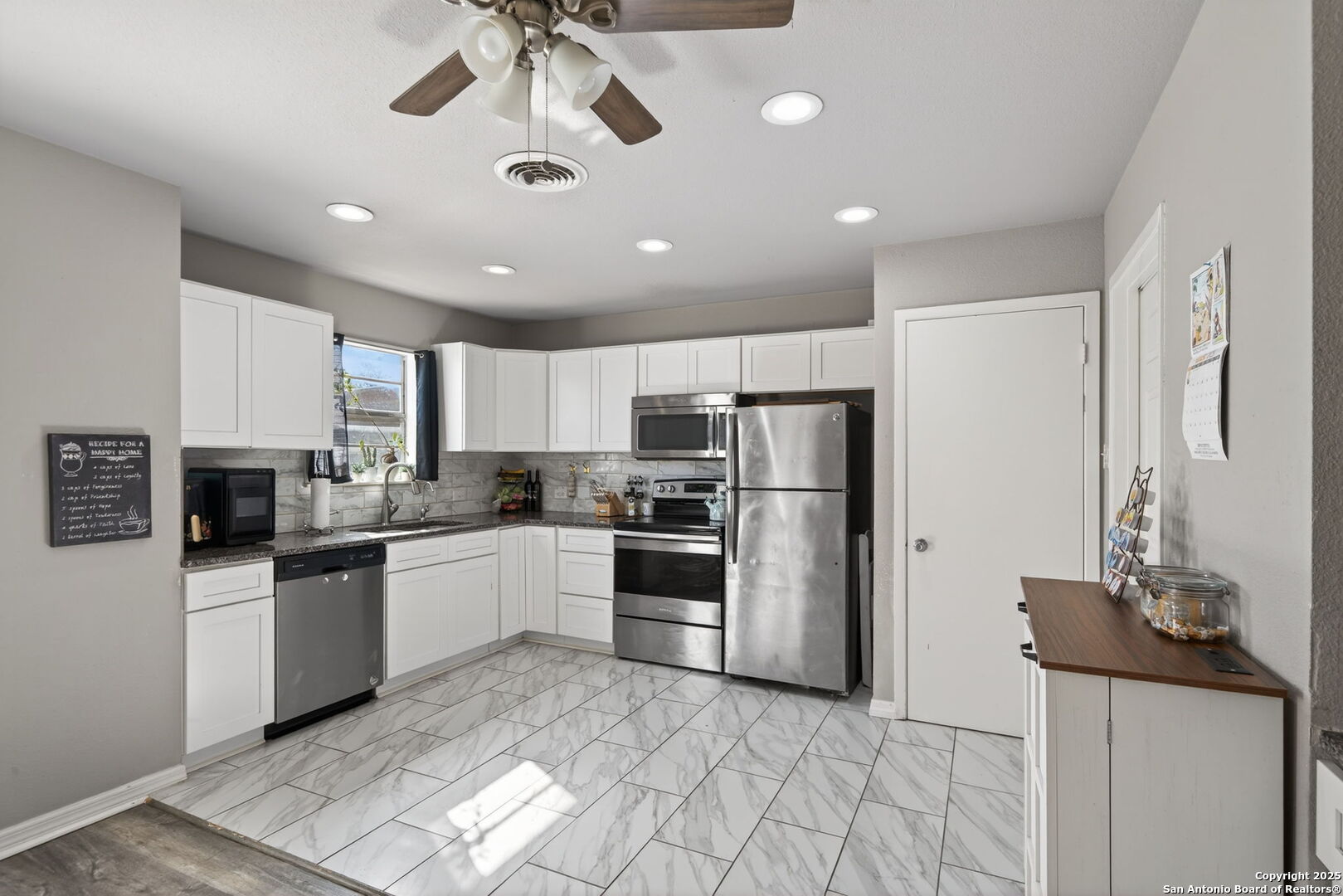 a kitchen with stainless steel appliances granite countertop a refrigerator a stove a sink a oven with a dining table and chairs