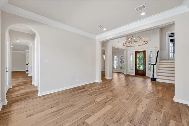 a view of a hallway with wooden floor and stairs