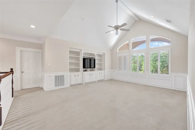 en empty room with windows and ceiling fan