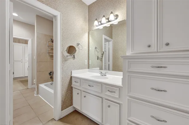 a spacious bathroom with a granite countertop sink a mirror and a shower