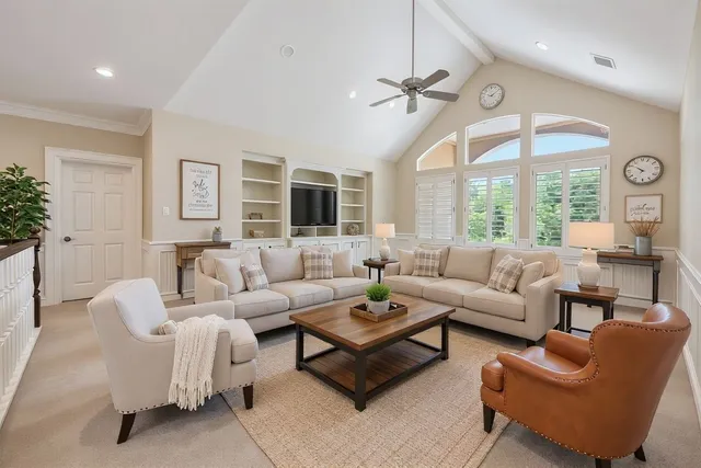 a living room with furniture potted plant and a large window