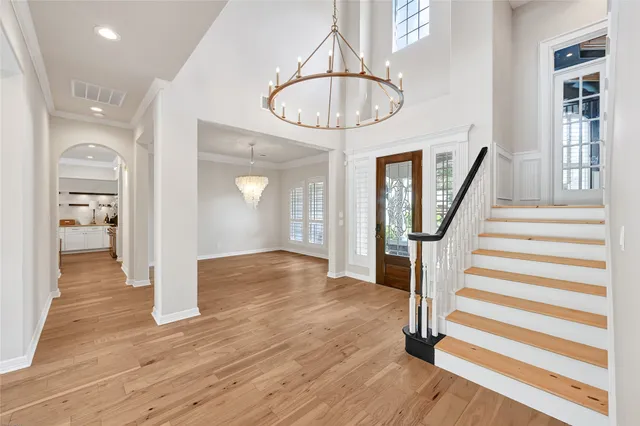 a view of a hallway with wooden floor staircase and a kitchen