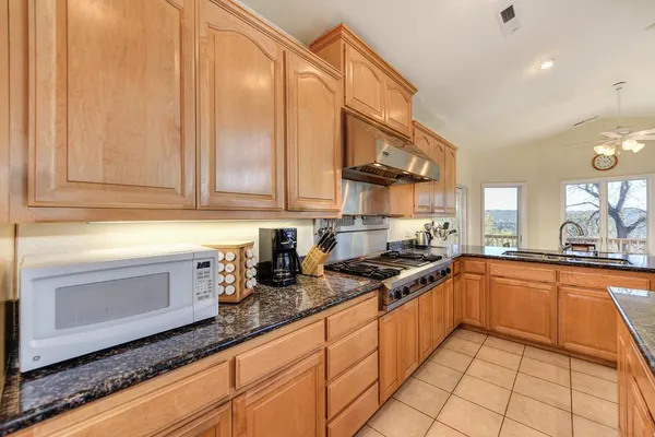 a kitchen with stainless steel appliances granite countertop a sink and cabinets