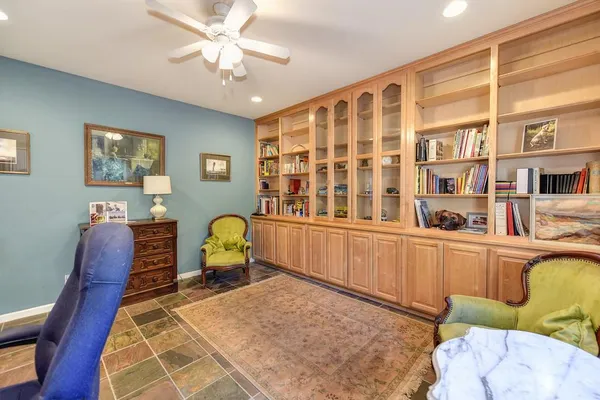 a view of a workspace with furniture and a window