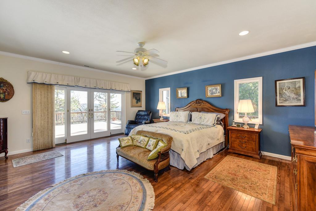 24200 Golden Ridge Drive Volcano, CA 95689 - Photo 25 of 58 a spacious bedroom with a large bed and a chandelier