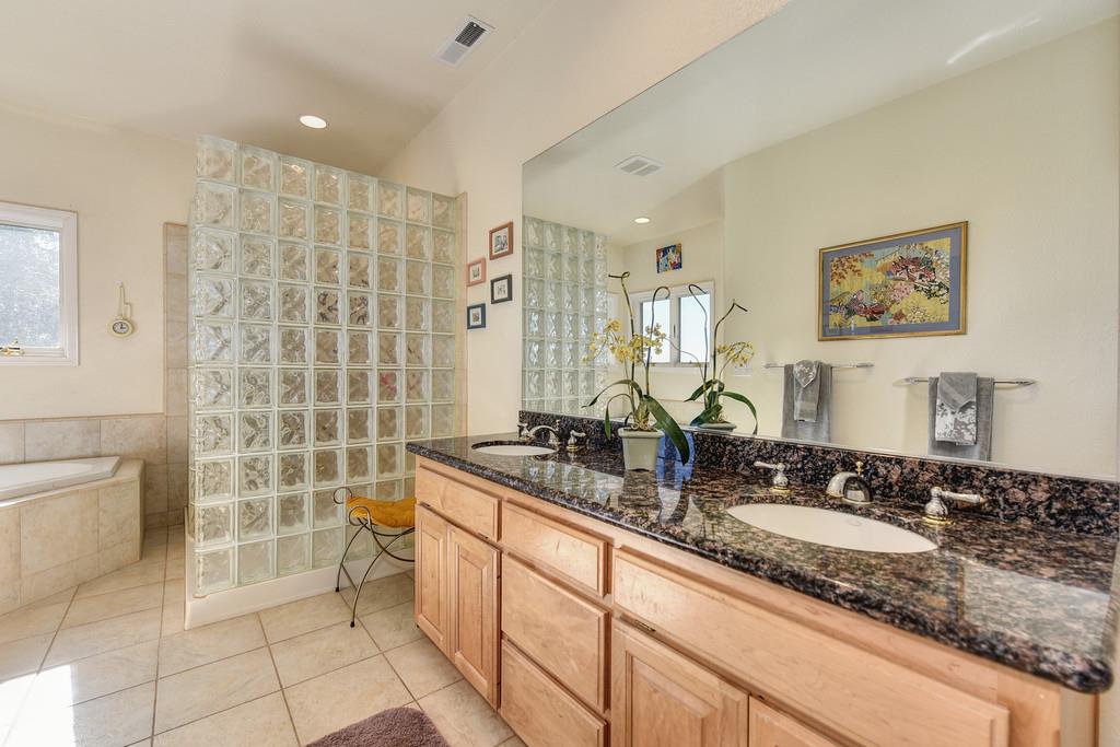 24200 Golden Ridge Drive Volcano, CA 95689 - Photo 27 of 59 a bathroom with a granite countertop sink and a mirror