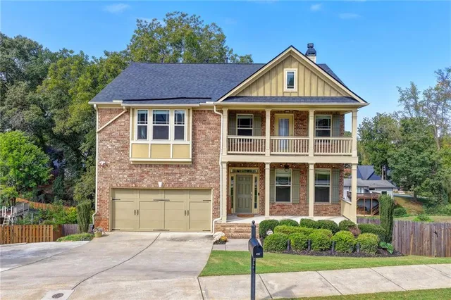 a front view of a house with a yard and potted plants