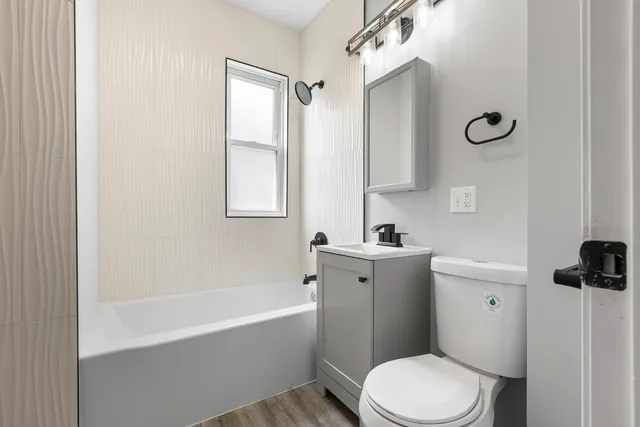 a bathroom with a granite countertop toilet sink and mirror