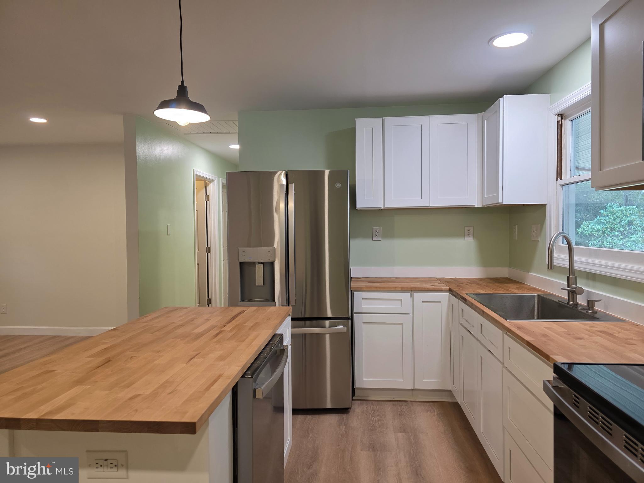 3939 Virginia Line Road Berkeley Springs, WV 25411 - Photo 6 of 51 a kitchen with kitchen island granite countertop a sink a counter space appliances and cabinets