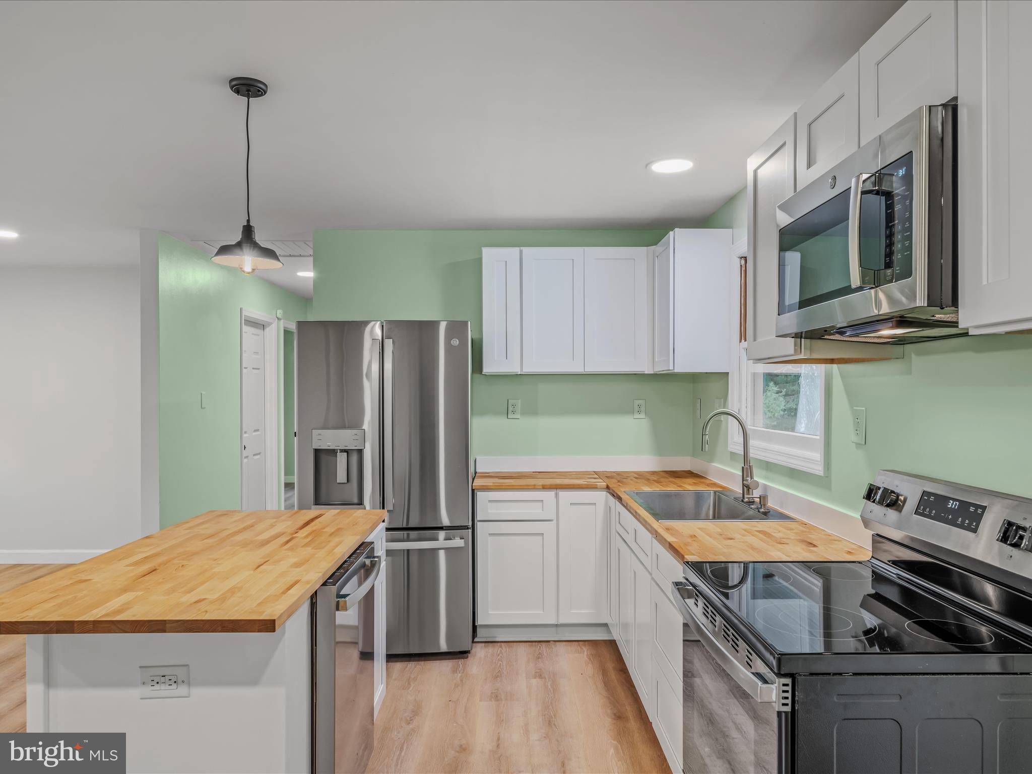 3939 Virginia Line Road Berkeley Springs, WV 25411 - Photo 9 of 51 a kitchen with stainless steel appliances granite countertop a sink stove and refrigerator