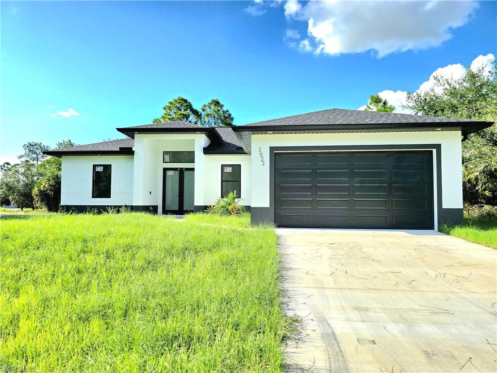 a front view of a house with a yard and garage
