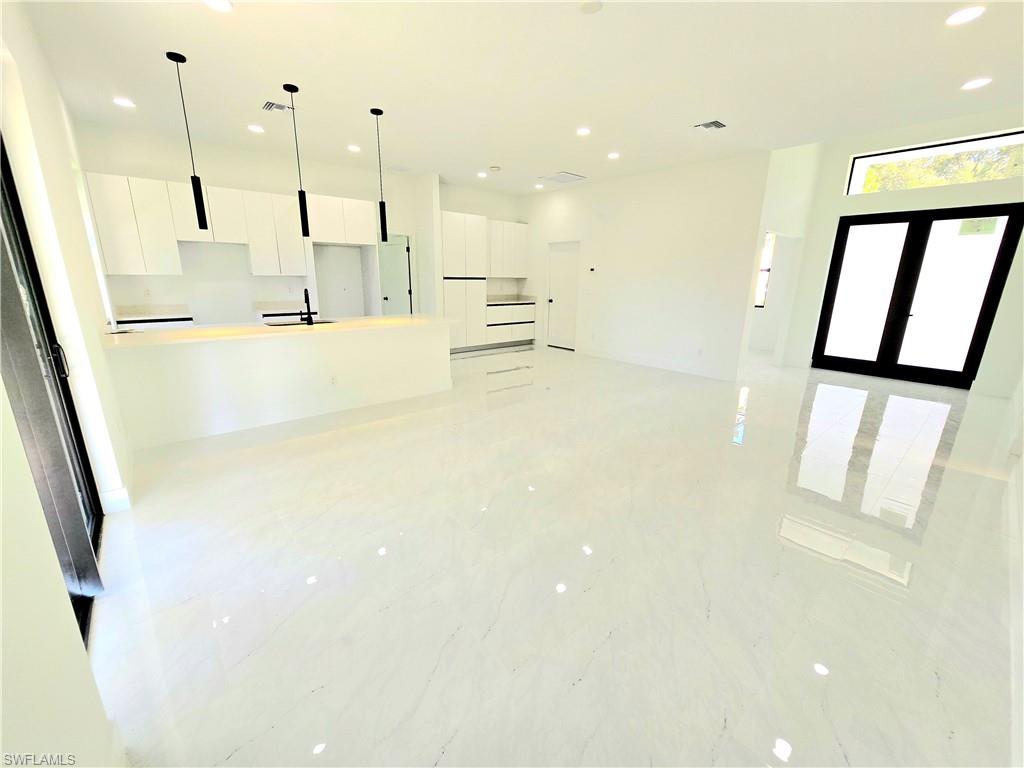 2522 Alice Place Lehigh Acres, FL 33971 - Photo 14 of 34 a view of kitchen with kitchen island wooden floor center island and stainless steel appliances