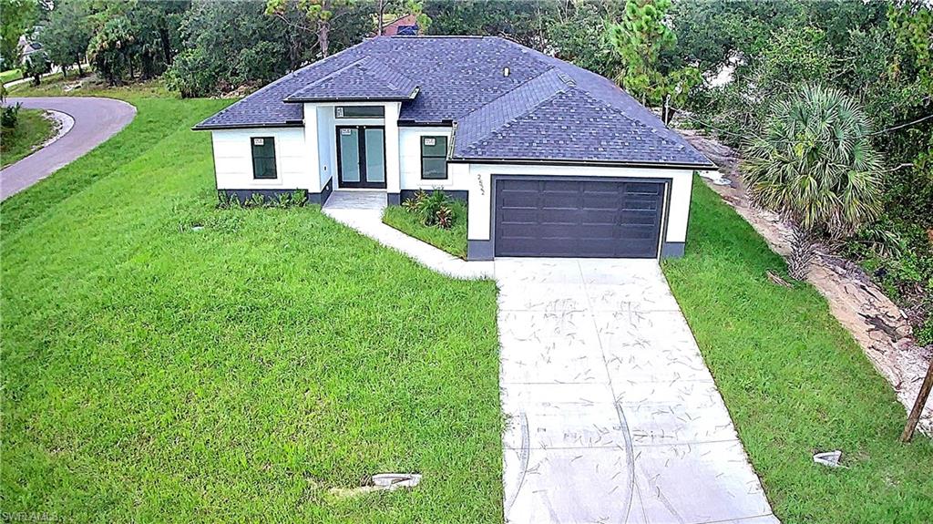 2522 Alice Place Lehigh Acres, FL 33971 - Photo 2 of 34 a front view of a house with garden