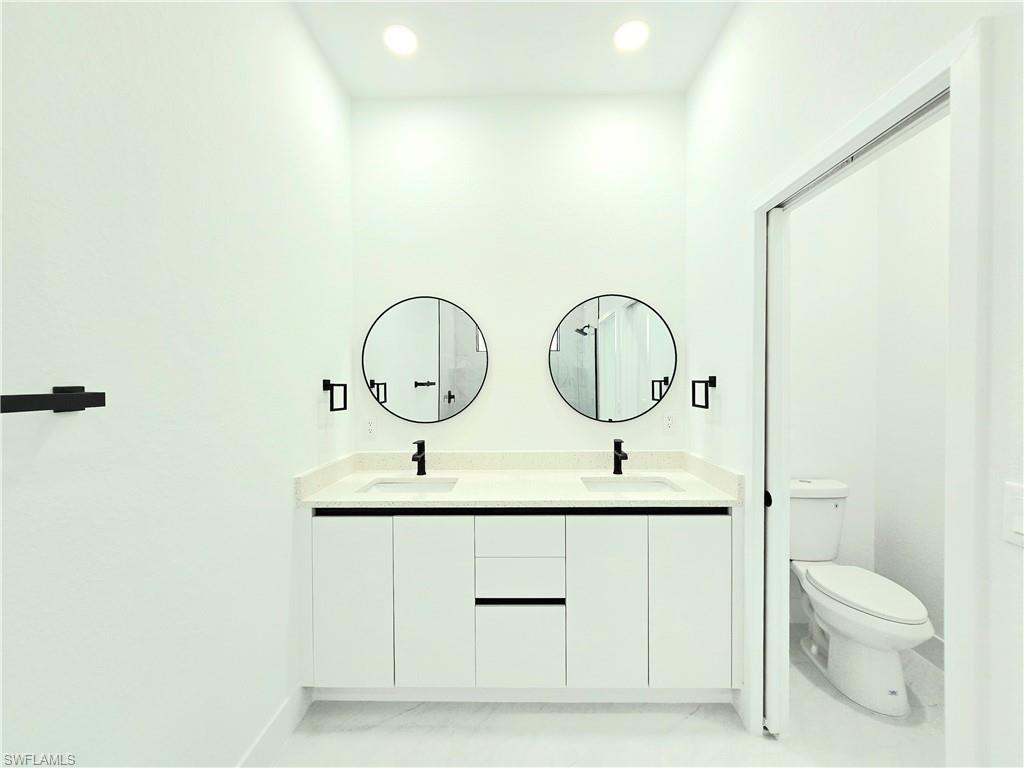 2522 Alice Place Lehigh Acres, FL 33971 - Photo 22 of 34 a bathroom with a toilet sink and mirror