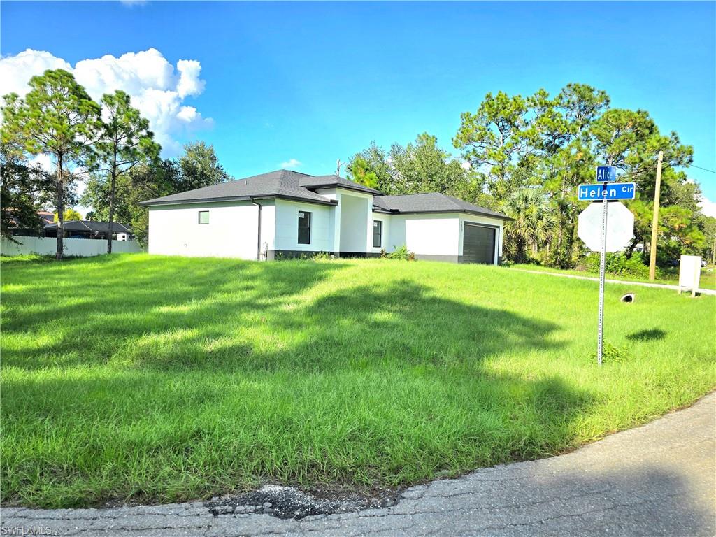 2522 Alice Place Lehigh Acres, FL 33971 - Photo 3 of 34 a house with green field in front of it
