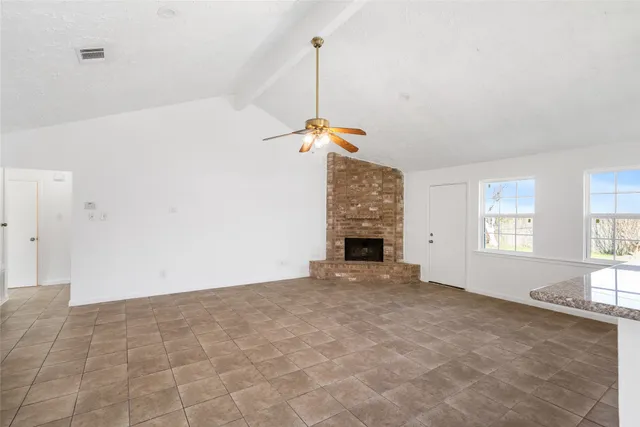 a view of empty room with fireplace and window