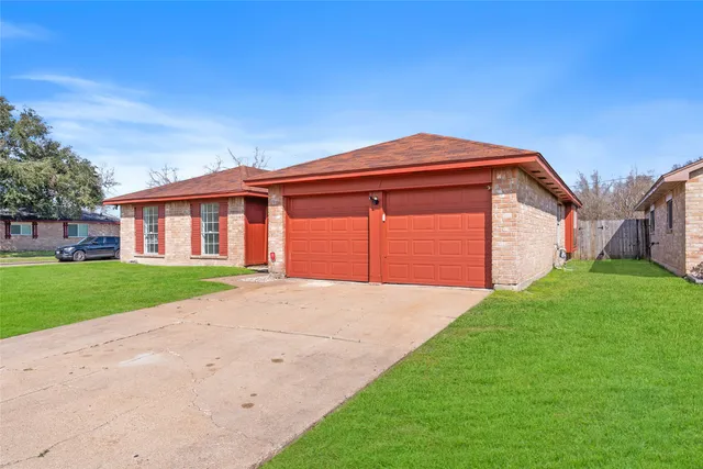 a view of a yard in front of a house with a large tree