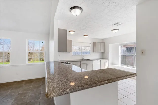 a large kitchen with kitchen island a sink stainless steel appliances and cabinets
