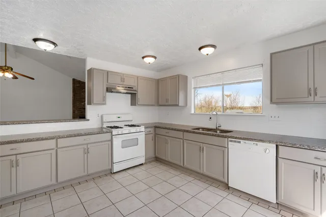 a kitchen with white cabinets appliances and a sink