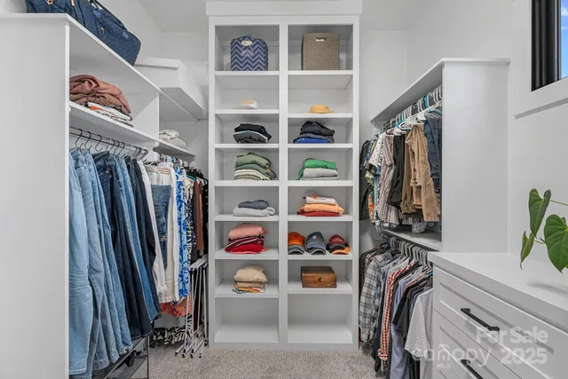 a view of walk in closet with clothes and shoes