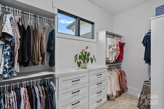 a view of walk in closet with clothes