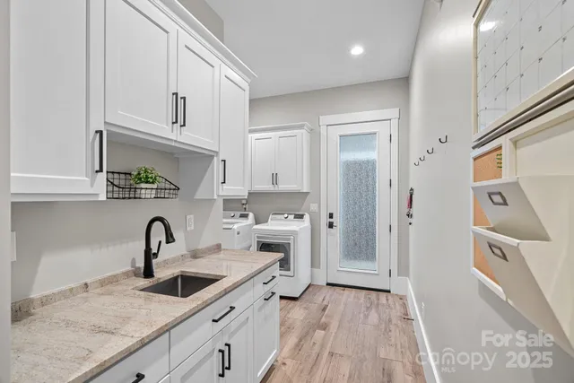 a kitchen with white cabinets and sink
