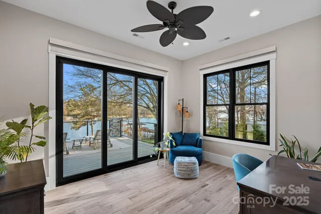 a living room with furniture and a large window with wooden floor