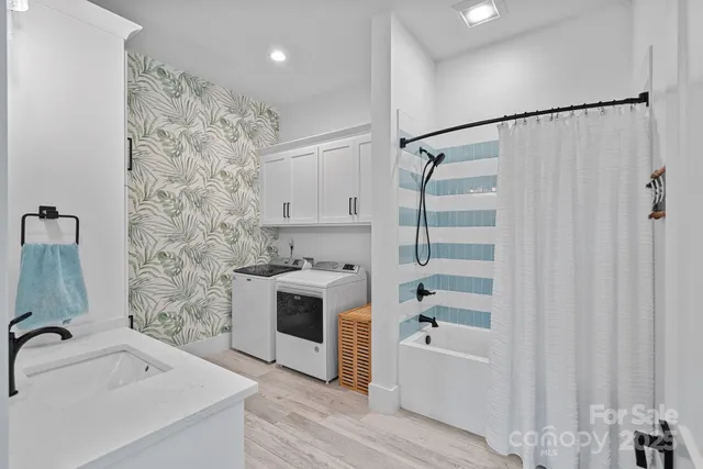 a living room with furniture a flat screen tv and kitchen view