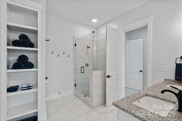 a en suite bathroom with a granite countertop sink mirror and window