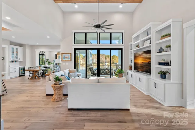 a living room with furniture large window and flat screen tv