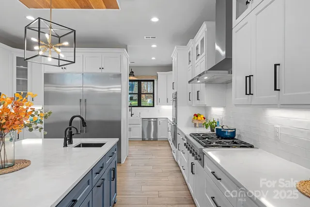 a kitchen with stainless steel appliances a sink stove and cabinets