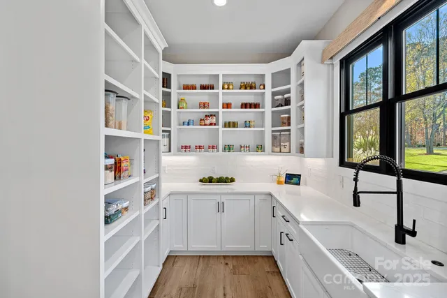 a view of cabinets with wooden floor and white walls