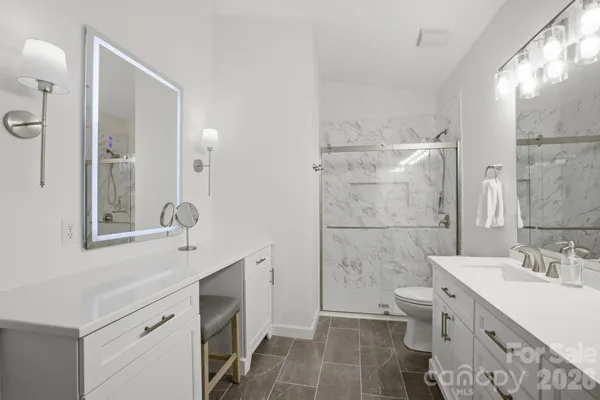 a bathroom with a double vanity sink mirror and toilet