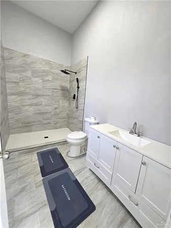 a bathroom with a granite countertop sink toilet and shower