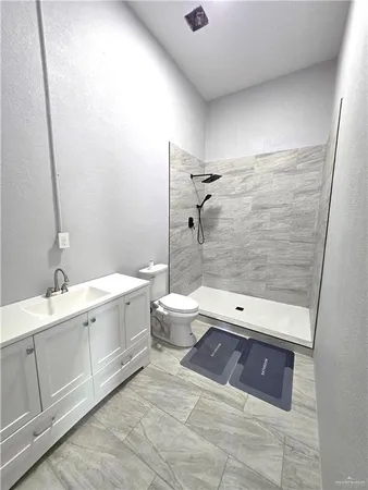 a bathroom with a double vanity sink toilet and shower
