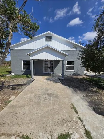 a front view of a house with yard and trees