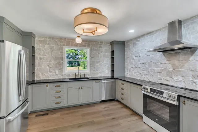 a kitchen with granite countertop a stove and a sink