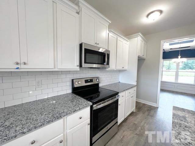 620 Ballance Road Fremont, NC 27830 - Photo 13 of 40 a kitchen with granite countertop white cabinets and black stainless steel appliances