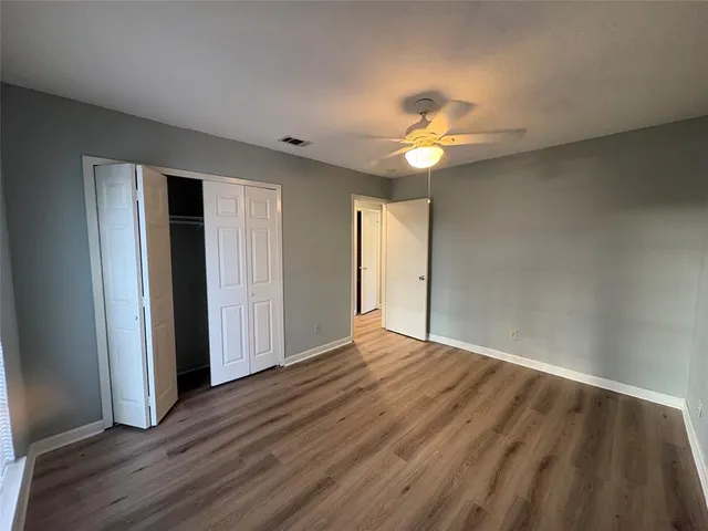 a view of an empty room with window and wooden floor