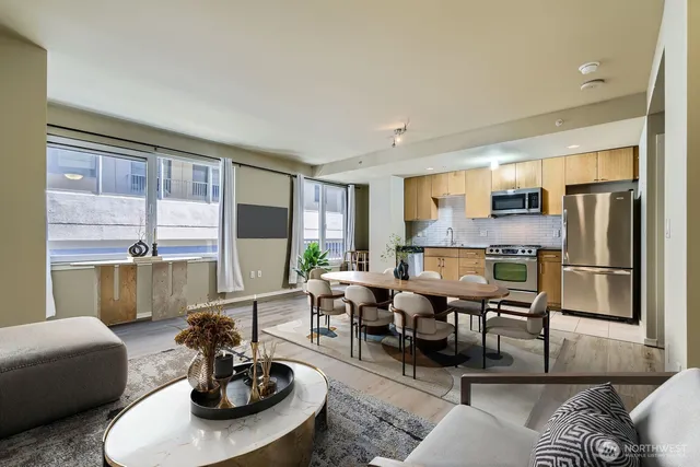 a view of kitchen with stainless steel appliances wooden floor and window