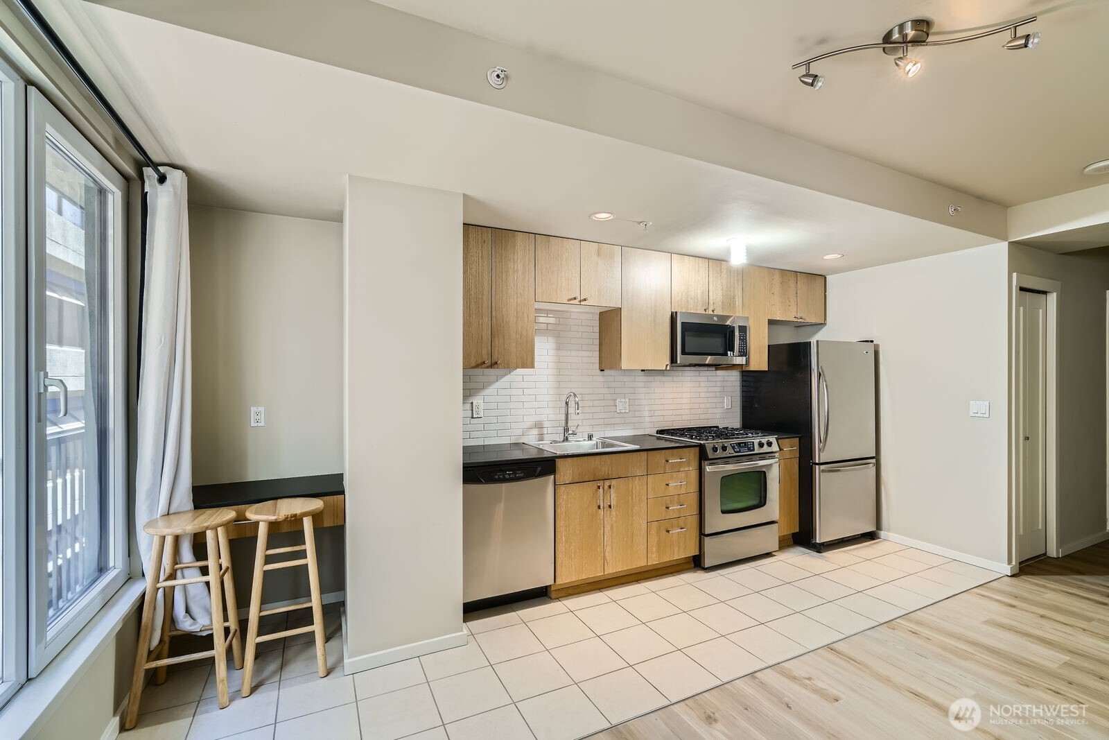 76 Cedar Street, Unit 806 Seattle, WA 98121 - Photo 5 of 21 a kitchen with stainless steel appliances granite countertop a stove top oven a sink and a refrigerator
