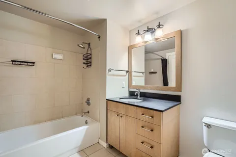 a bathroom with a granite countertop sink mirror and bathtub
