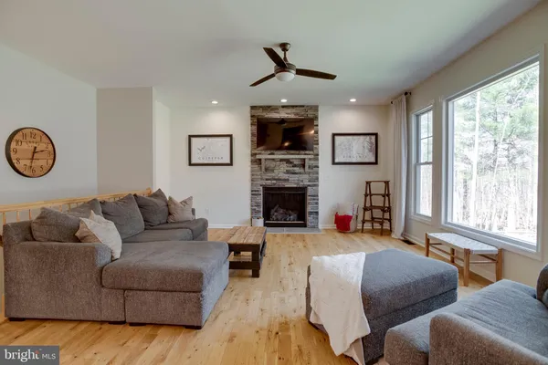 a living room with furniture a fireplace and a large window
