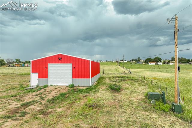 12550 Smith Road Peyton, CO 80831 - Photo 8 of 35 View of outbuilding featuring a rural view and a garage