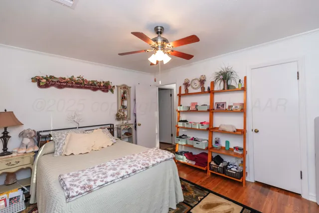 a bedroom with a bed and a bookshelf with wooden floor