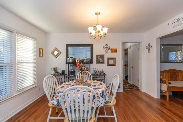 a view of a dining room with furniture a chandelier and wooden floor