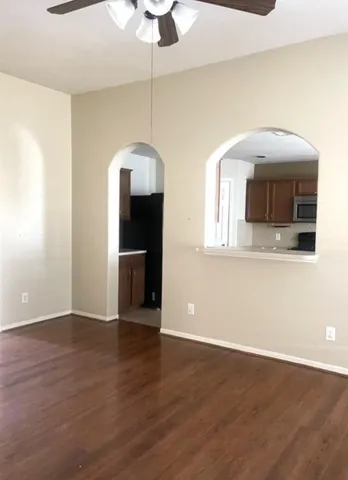 a view of a livingroom with wooden floor and a ceiling fan
