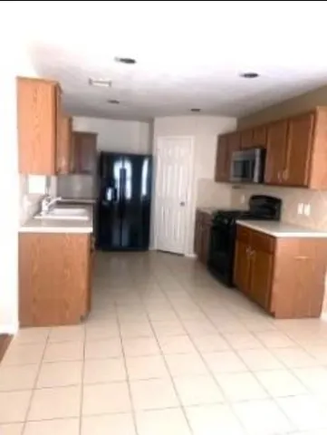 a kitchen with stainless steel appliances granite countertop a stove a sink dishwasher and a refrigerator