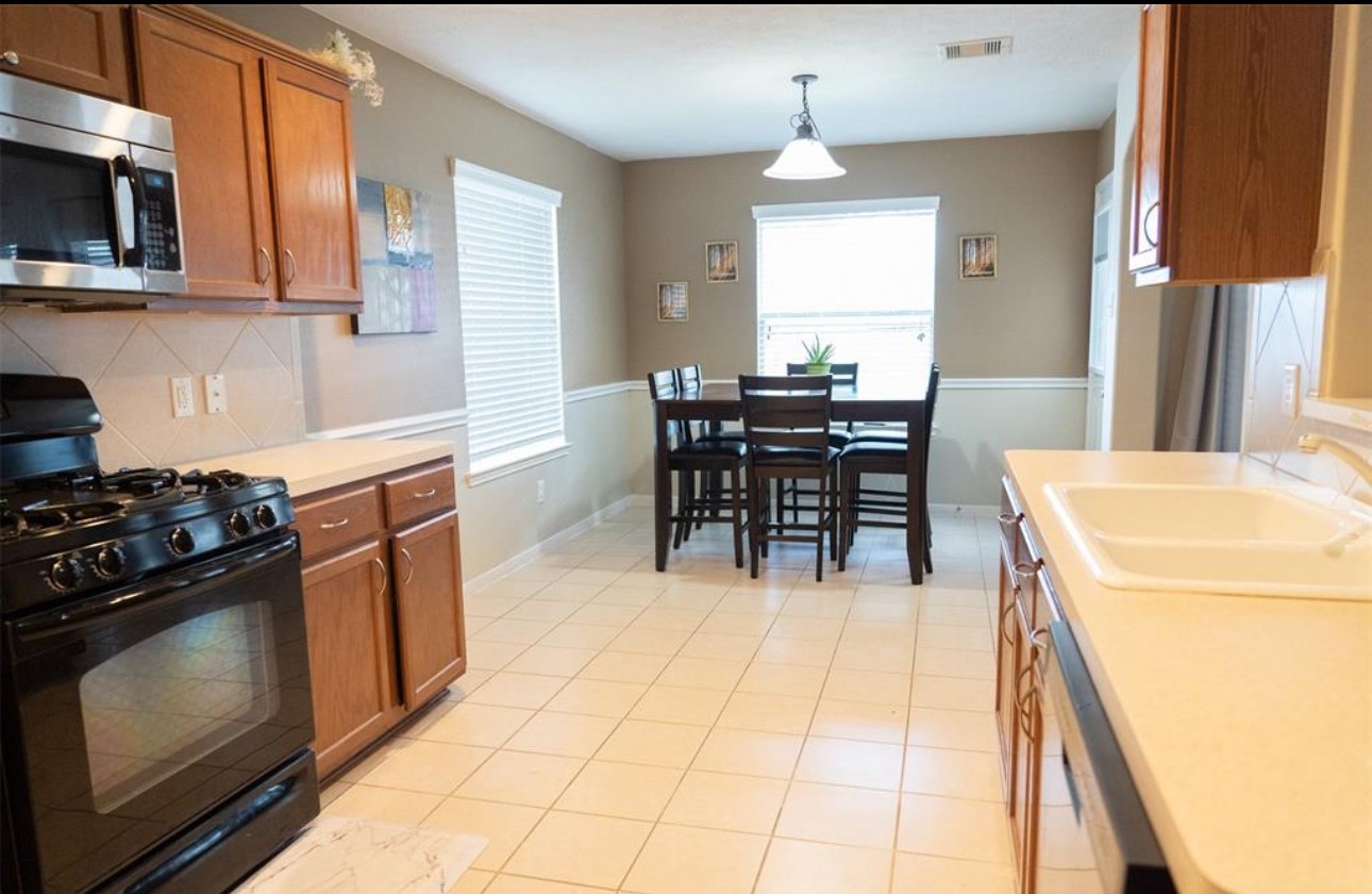 21942 Gosling Cedar Place Spring, TX 77388 - Photo 39 of 40 a kitchen with a stove a sink and a refrigerator